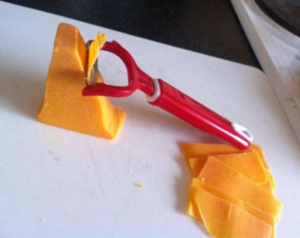 Un épluche-légumes pour couper de fines tranches de fromage