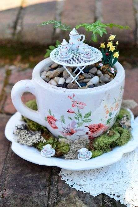 Une tasse avec un petit jardin et une dînette miniature