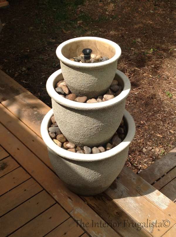 Fontaine d'eau avec des pots en béton superposés