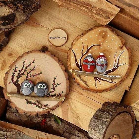 Wooden logs with painted owls on pebbles