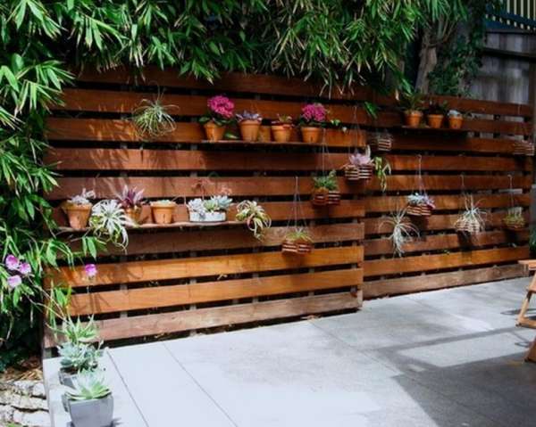 Une belle clôture en palette qui fait aussi jardinière