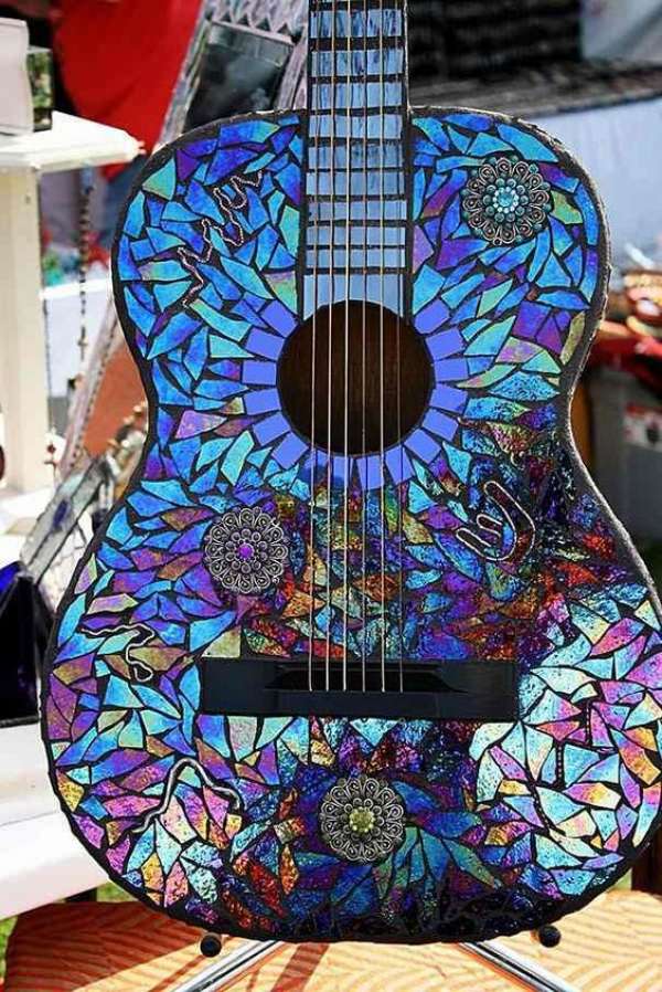 Une guitare recouverte d'une mosaïque de CDs