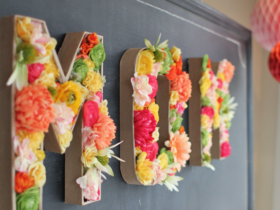 Lettre en papier maché décorée avec des fleurs artificielles