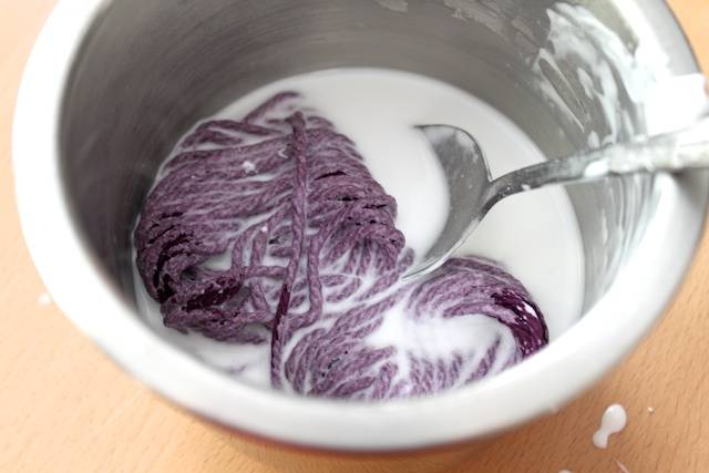 bobine de fil dans un mélange de colle blanche et eau dans un bol