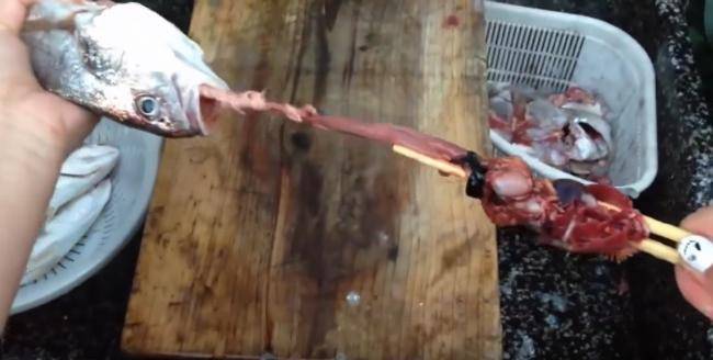 retirer les boyaux du poisson avec des baguettes chinoises