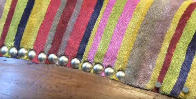 cloutage du tissu de tapisserie sur un fauteuil ancien