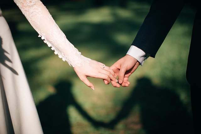 jeunes mariés se tenant la main le jour du mariage