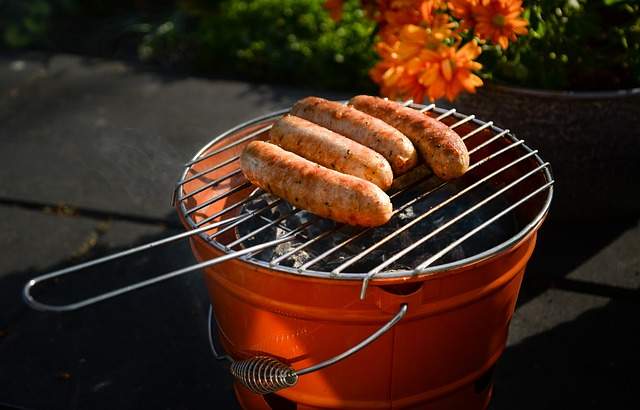seau à barbecue avec des saucisses entrain d'être grillées