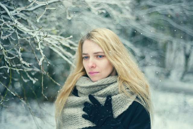 femme triste sous la neige et qui risque l'hypothermie