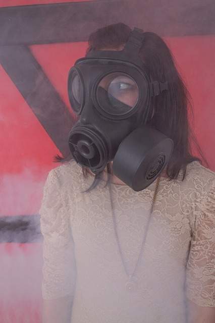 fille dans un nuage de fumée portant un masque à gaz