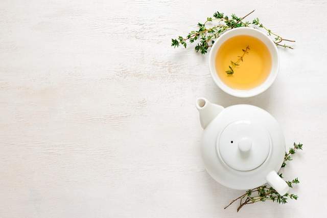 feuilles de thé vert tasse de thé et théière 