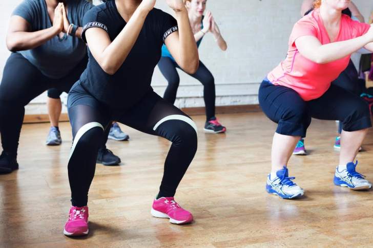 Femmes dans une salle de sport qui font des squats