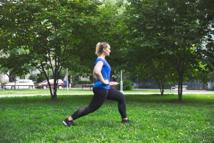 femme sportive qui fait des fentes dans un jardin