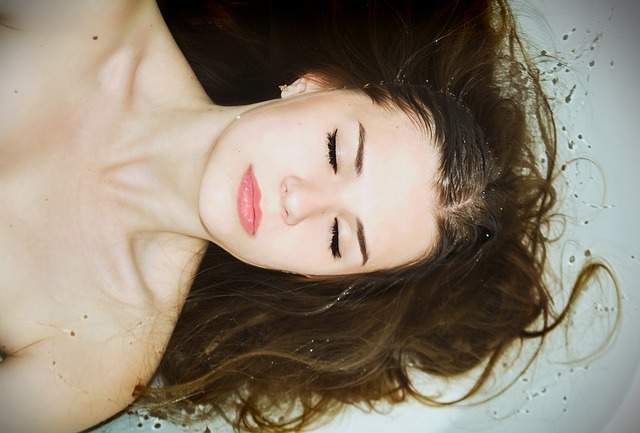 femme couchée dans un bain avec les cheveux dans l'eau