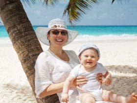 Maman protégeant son bébé du soleil sur une belle plage