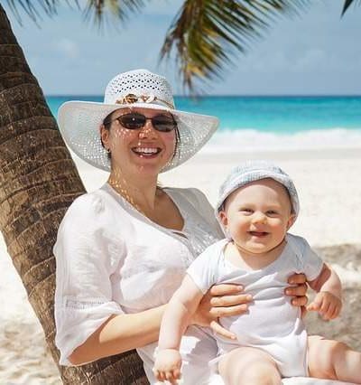 Maman protégeant son bébé du soleil sur une belle plage