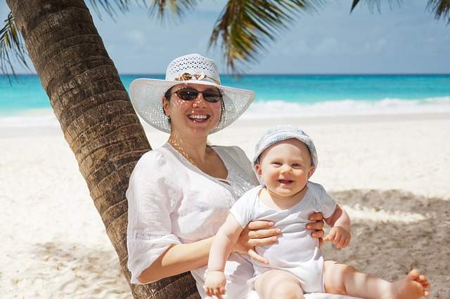Maman protégeant son bébé du soleil sur une belle plage