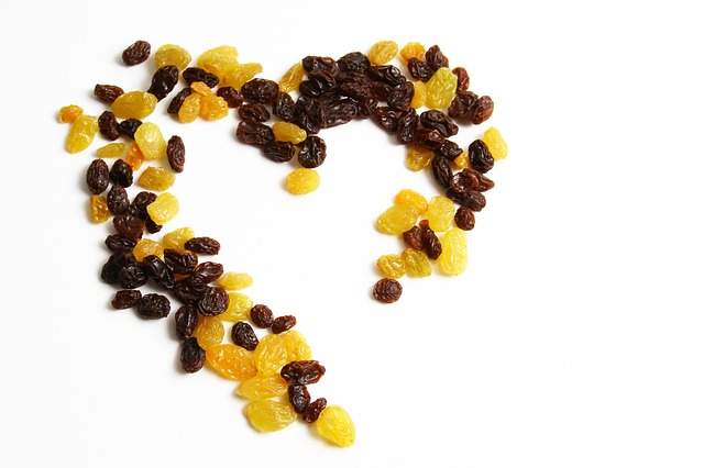 raisins secs blonds et noir disposés en forme de cœur