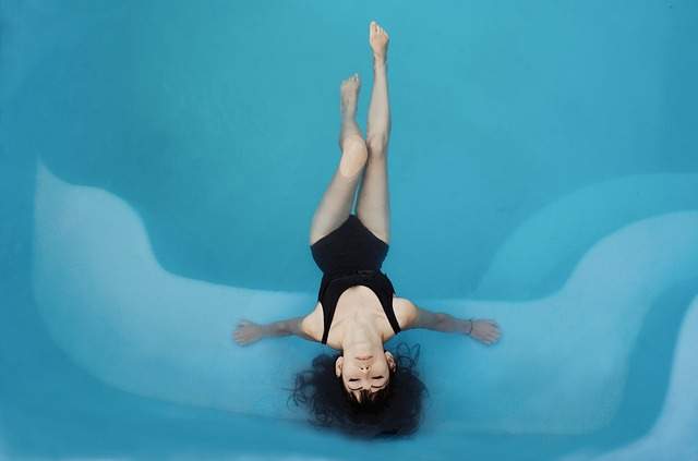 femme dans une piscine avec les cheveux dans l'eau