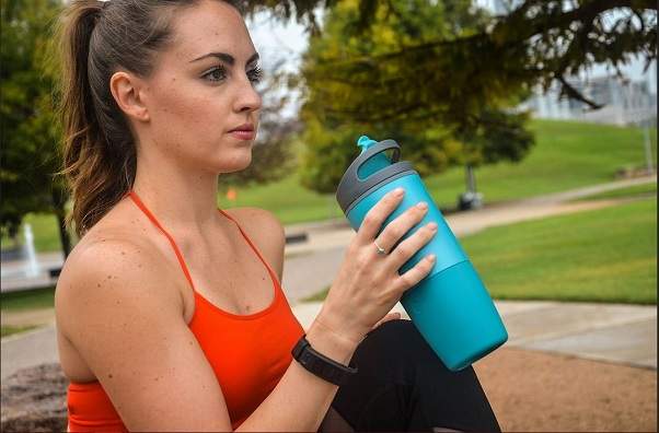femme qui a une gourde intelligente qui envoie incite à boire plus d'eau