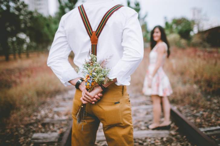 homme qui offre un bouquet de fleurs surprise à sa femme ou sa fiancée