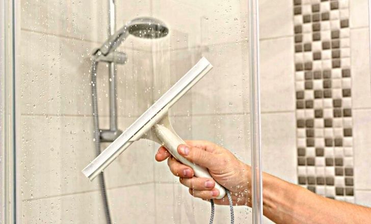 Passez régulièrement la raclette pour nettoyer la cabine de douche