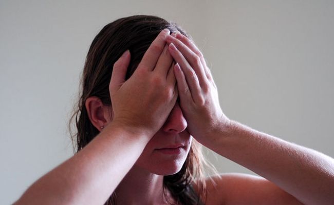 Une femme plaçant ses paumes de main sur les yeux