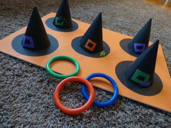 Un jeu de lancer d'anneaux avec des anneaux colorés et les chapeaux de sorcières qui y correspondent