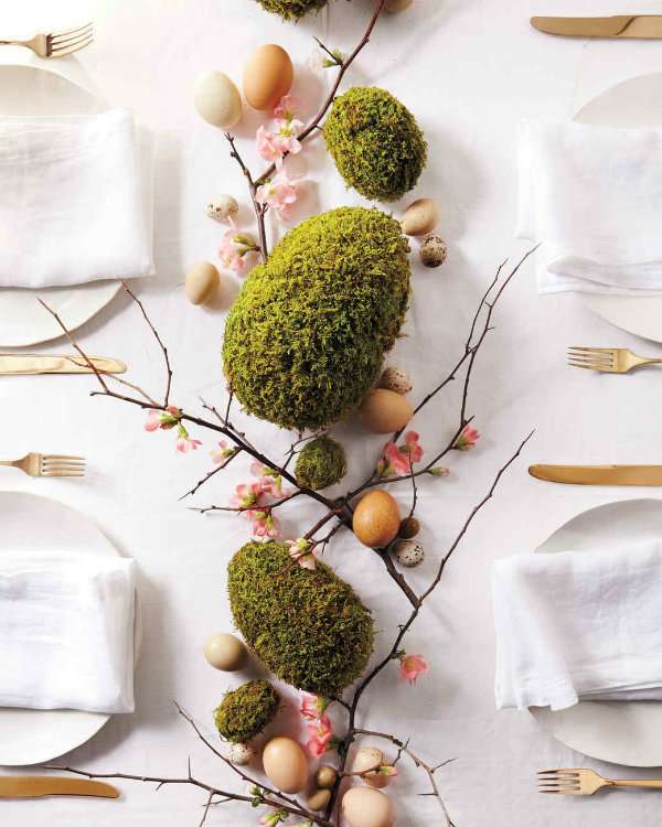 Centre de table avec des œufs en mousse et des branches d'arbre