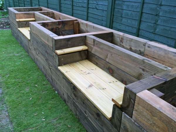 Un grand jardin surélevé avec des bancs pour s'y installer