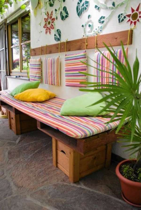 Salon de jardin en palettes avec des coussins suspendus