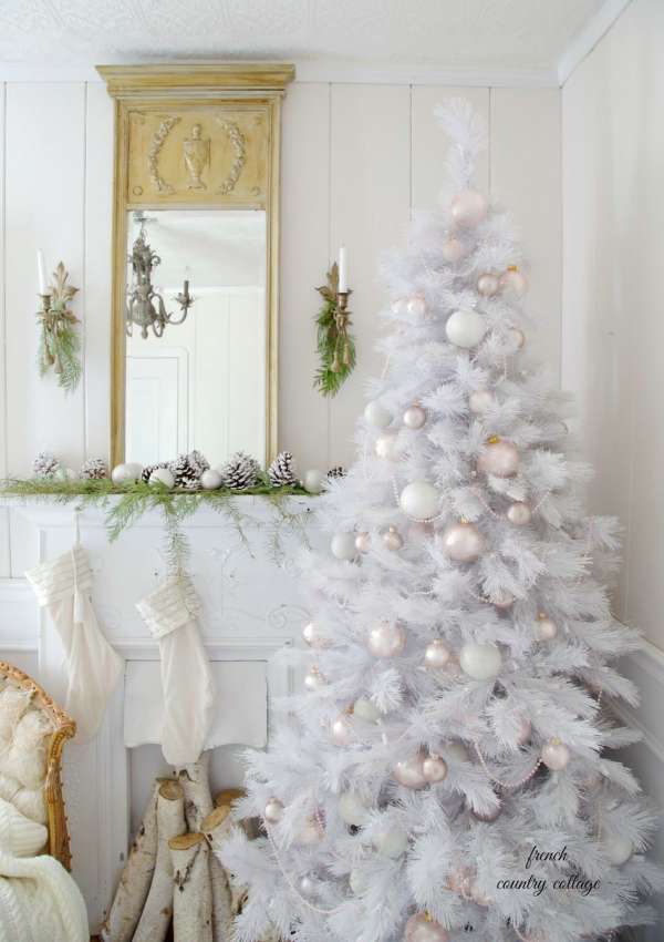 Un sapin de Noël blanc très chic près de la cheminée