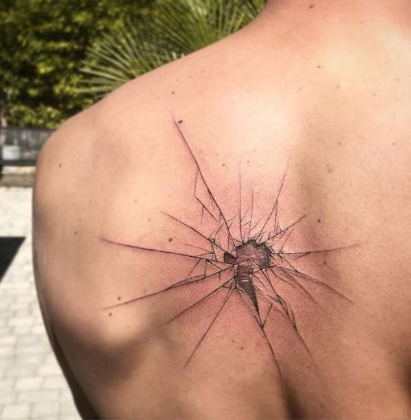 Un tatouage réussi donnant l'effet d'un impact sur du verre