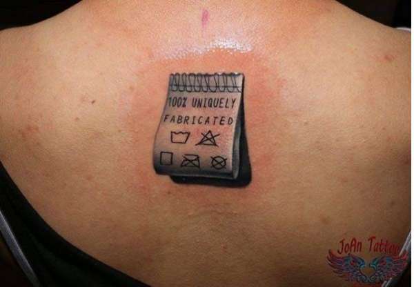 Un petit tatouage réaliste et original d'une étiquette de vêtement