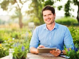 Jeune homme dans un jardin avec une tablette à la main
