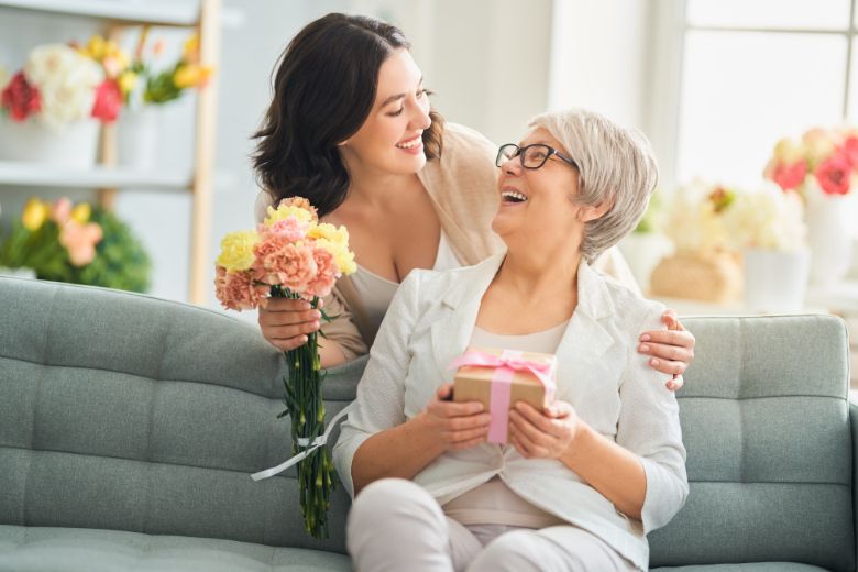 Fête des mères, une fille offrant des fleurs à sa maman