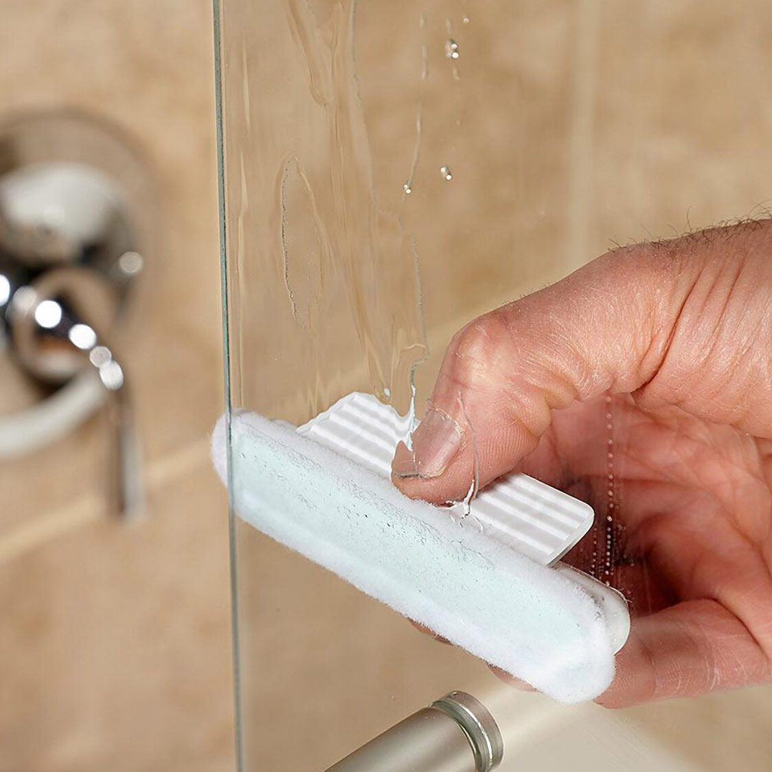 Nettoyage d'une porte de douche en verre.