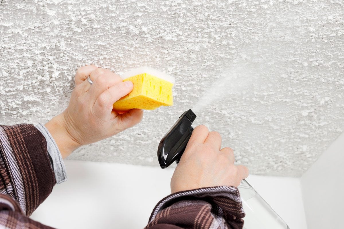Lavage délicat d'une tache sur un plafond avec une éponge