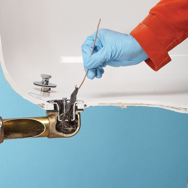 Personne nettoyant une bonde de baignoire