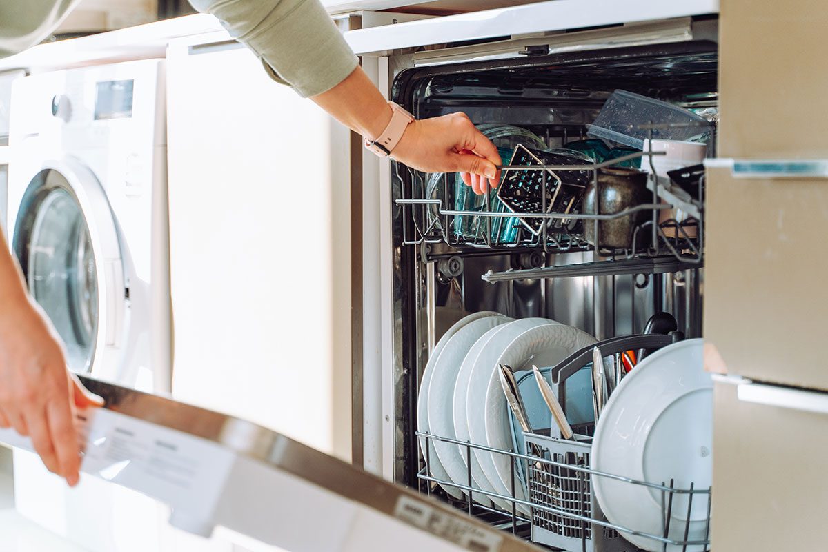 Mains chargeant un lave-vaisselle