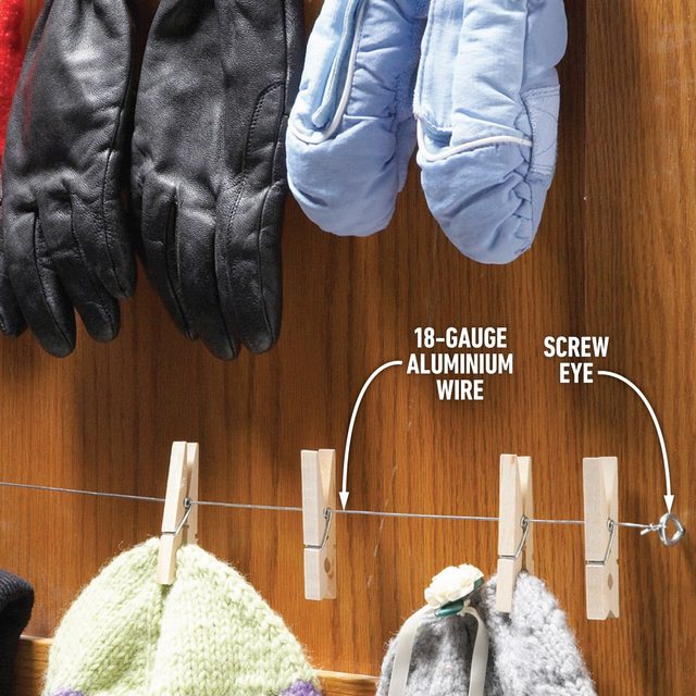 Des pinces à linge sur un fil tendu à l'arrière d'une porte pour faire sécher des gants.