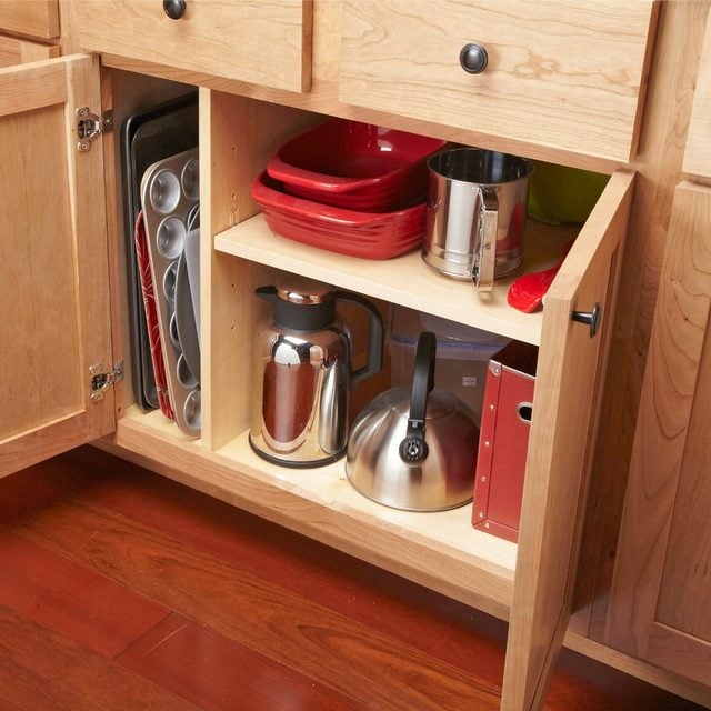 Un placard avec une nouvelle cloison verticale pour le rangement des plats.