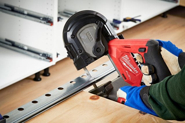 Un rail métallique est vissé sur un mur avec des marques verticales indiquant les montants.