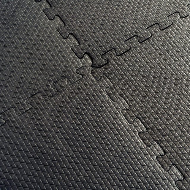 Des dalles de sol en caoutchouc noir emboîtables.