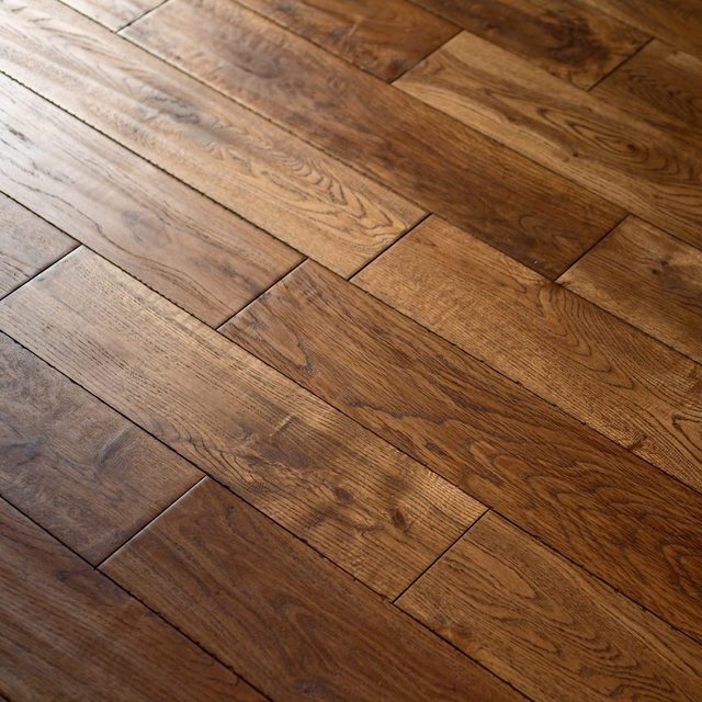 Un parquet en bois foncé posé en chevrons.