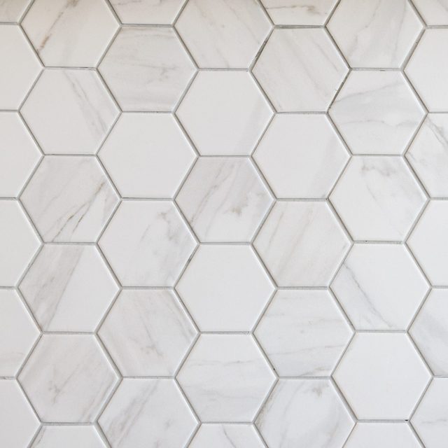 Des carreaux de marbre hexagonaux blancs et gris.