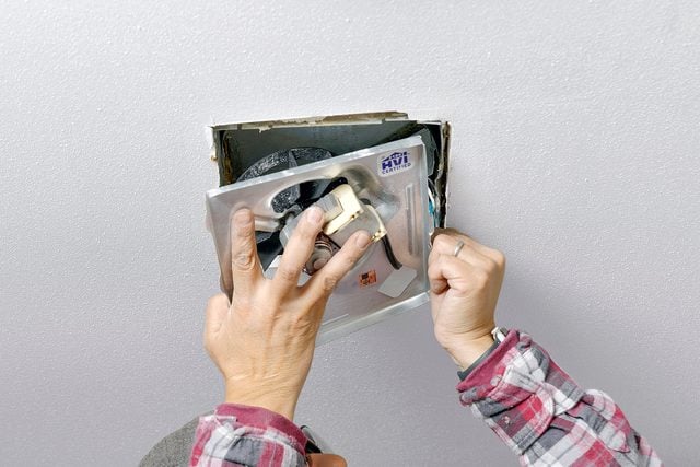 Mise en place et fixation du nouveau ventilateur dans son caisson au plafond.