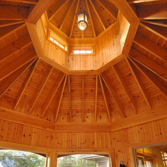 Un plafond en bois en forme de dôme avec des poutres partant d'un luminaire central.