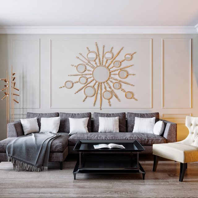 Un canapé d'angle gris avec des coussins blancs dans un salon moderne.