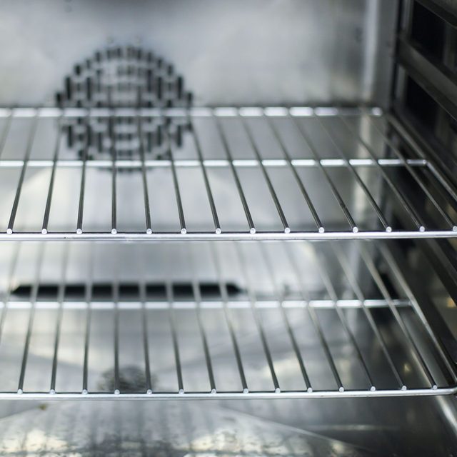 L'intérieur vide d'un four propre avec ses grilles métalliques.